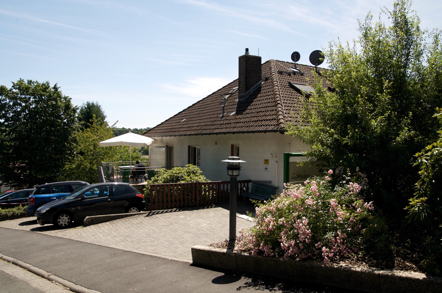 Haus Martin von der Straße aus gesehen, mit Parkplatz und Garten